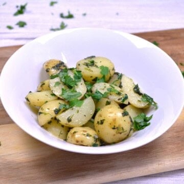 A bowl of Hungarian parsley potatoes made with baby potatoes and fresh herbs.