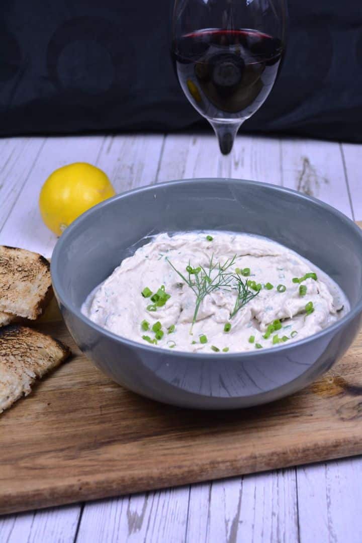 Serving Creamy smoked mackerel spread in a serving bowl garnished with fresh dill and served with toasted bread slices and lemon wedges.
