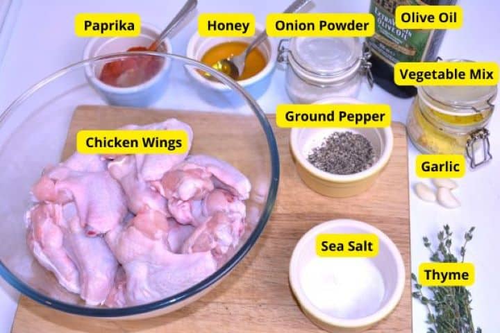 Ingredients Ingredients for air fryer honey garlic chicken wings including paprika, honey, fresh garlic, and thyme.