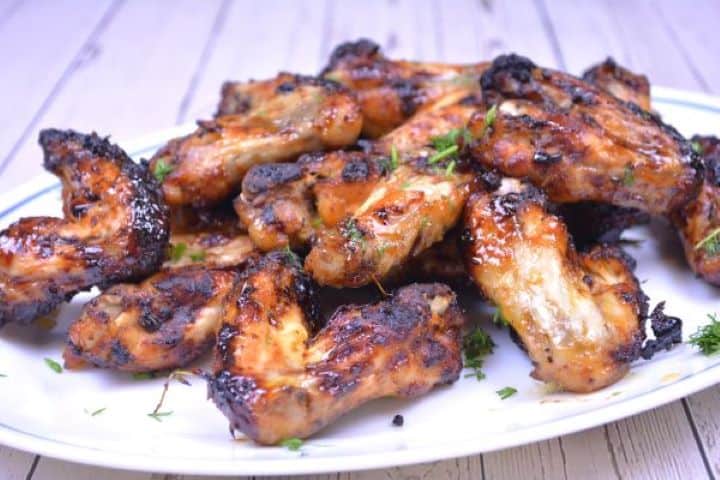 Served Golden sticky air fryer honey garlic chicken drumettes and flats arranged on a platter.