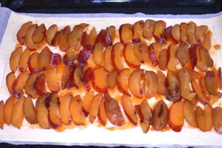 Plum on Pastry Fresh plum slices arranged in neat overlapping rows over apricot jam on a puff pastry sheet.