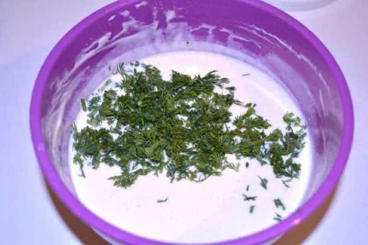 Dill Stirring finely chopped fresh dill into the creamy yogurt mayonnaise sauce.