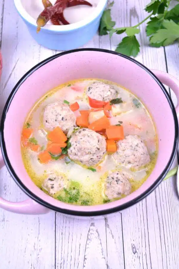 Romanian Meatball Soup-Served In Little Pink Pot With Pickled Chili and Parsley