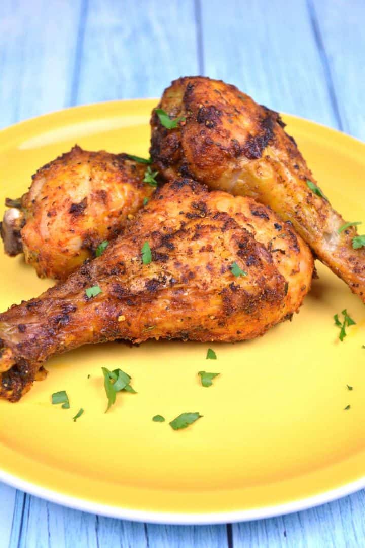 Serving Crispy golden brown air fryer chicken drumsticks served on a plate.