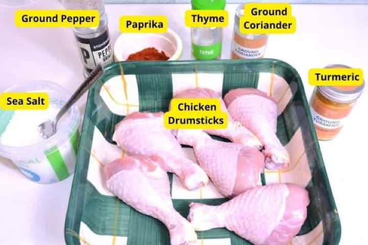 Ingredients Ingredients for air fryer drumsticks including raw chicken, olive oil, sweet paprika, thyme, and spices.