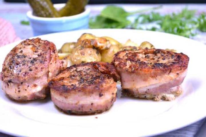 Served Close-up of succulent bacon-wrapped pork medallions showing a juicy tender center and crisp bacon crust.