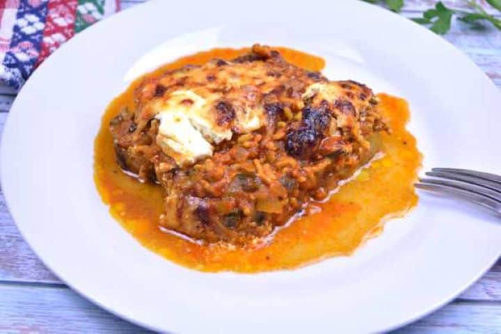 Serve A hot serving of Turkish aubergine moussaka with melting layers of meat, yogurt, and cheese served with fresh bread.
