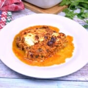 Authentic Turkish moussaka (Patlıcan Musakka) with golden melted cheese and yogurt gratin served on a white plate.
