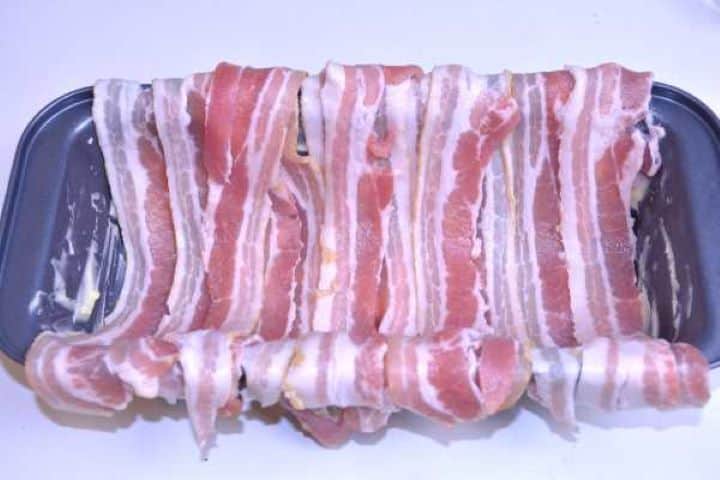 Bacon Buttered loaf tin lined with overlapping smoked bacon strips with ends hanging over the sides.