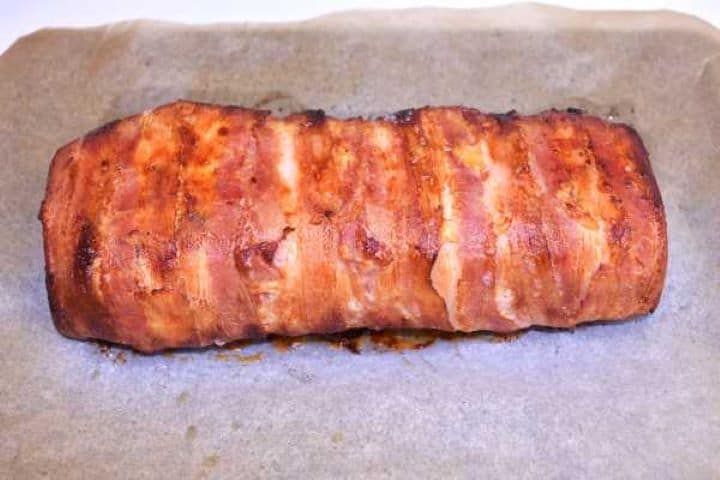 Golden crispy bacon wrapped turkey meatloaf fresh from the oven with rendered copper crust.