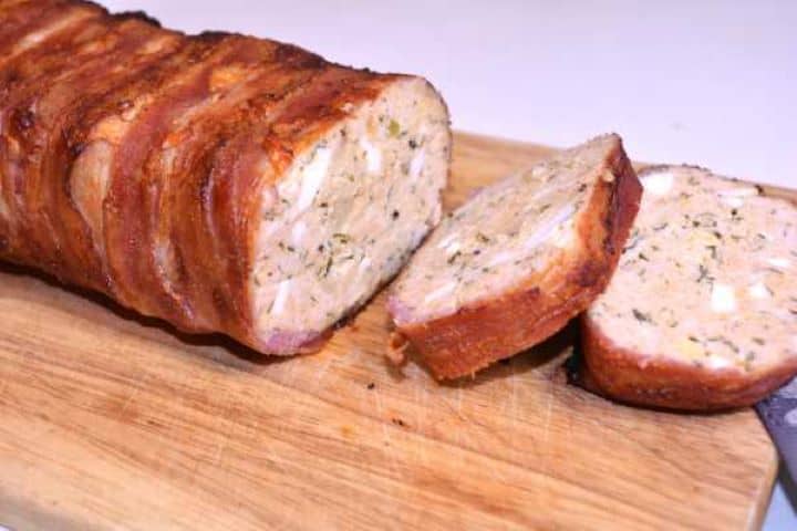 Sliced Two thick slices of juicy bacon wrapped turkey meatloaf showcasing the tender texture and crispy bacon crust.