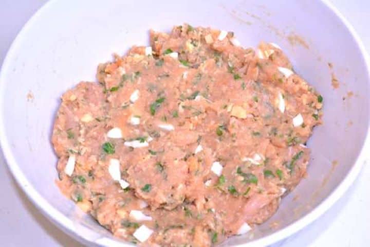 Meatloaf Gently folding diced hard-boiled eggs into the seasoned turkey mince paste.