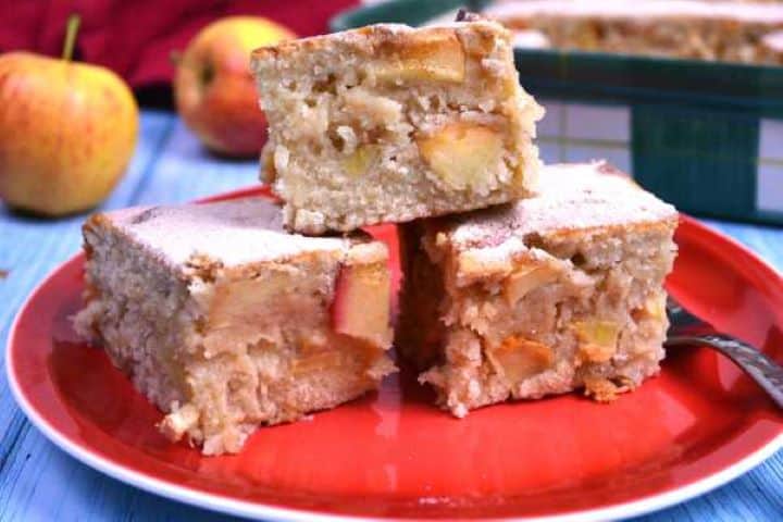 Three slices of rustic apple cake showing the tender crumb and juicy unpeeled apple chunks.