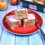Freshly baked easy apple cake bars dusted with powdered sugar and served on a plate.
