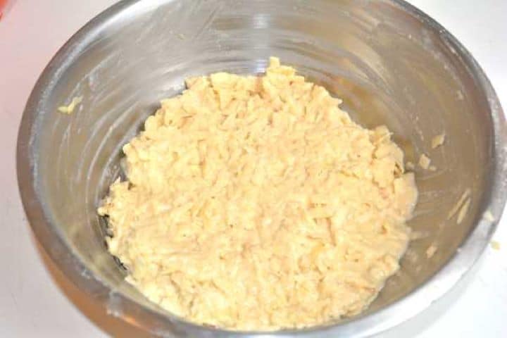 Thick grated apple fritter drop-batter mixed in a bowl without milk or melted butter