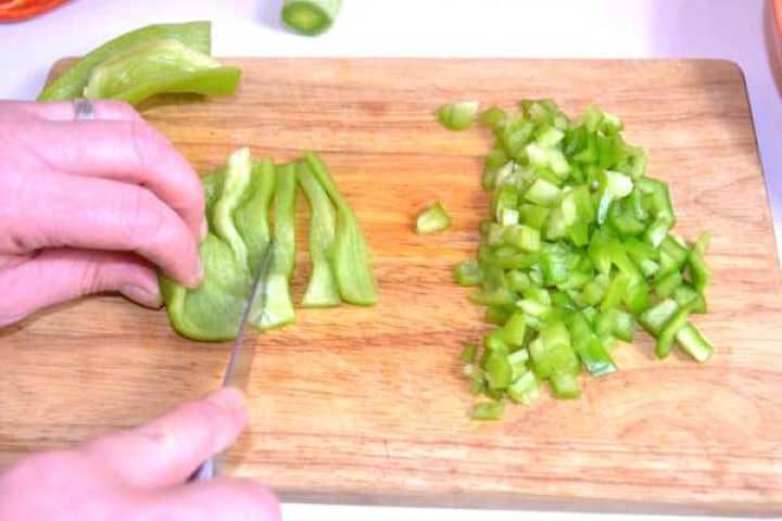 Green Pepper Cut in Cubes on the Chopping Board