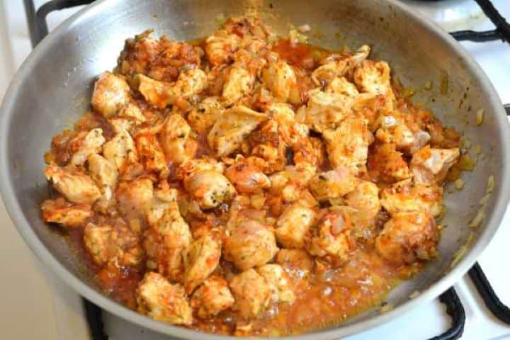 Stirring the turkey meat and onions to evenly coat them with the Hungarian paprika and aromatic spices.