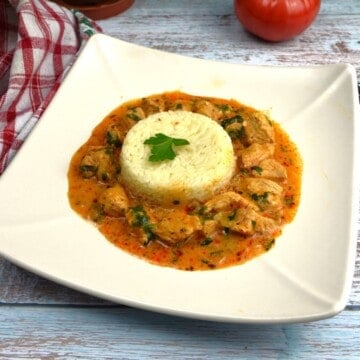 A delicious portion of easy turkey paprikash served with steamed white rice and fresh parsley garnish.