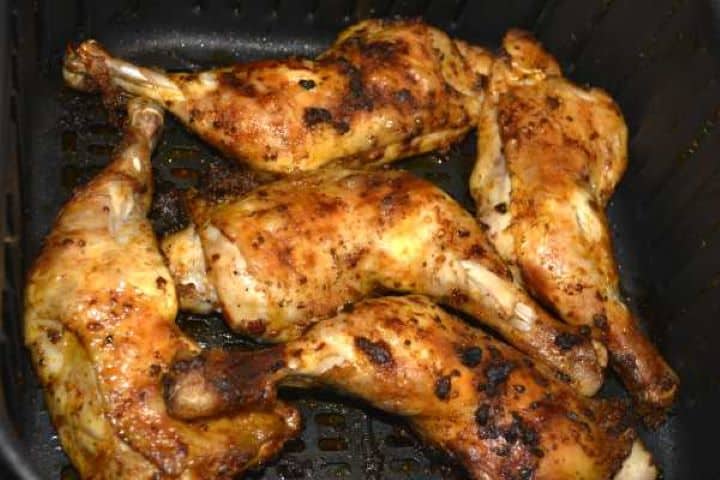 fried Perfectly golden brown and crispy air fryer whole chicken legs finishing the high-heat crisp phase in the basket.