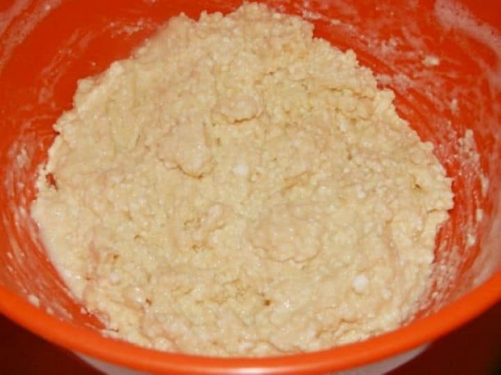 Cottage Cheese Donuts-Cottage Cheese and Wheat Flour Mixing the soft dough for Túrófánk by combining strained cottage cheese with eggs and flour in a bowl.