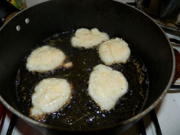 Cottage Cheese Donuts-Frying Donuts Dropping spoonfuls of cottage cheese donut batter into a pan of hot oil using the traditional two-spoon method.