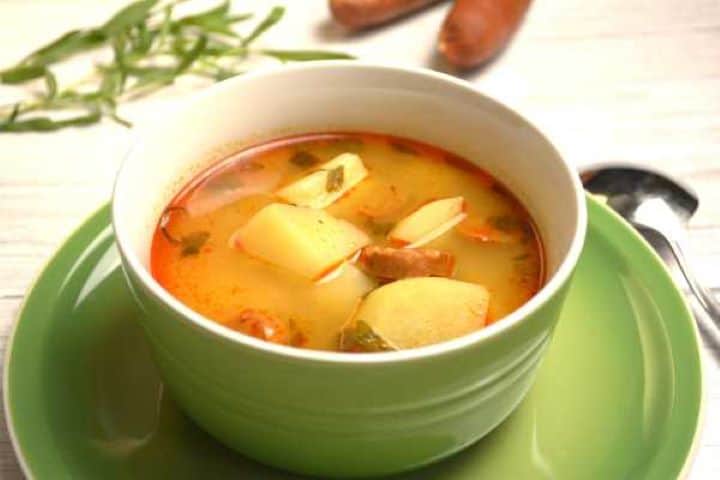 Hungarian Potato Soup With Sausages Served in Green Bowl