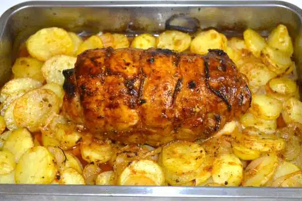 Ham and Cheese Stuffed Pork Loin-Stuffed Pork Loin in the Roasting Tray With Potatoes and Onion Ready to Serve
