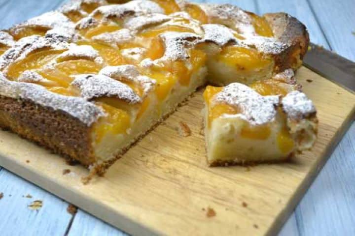 A close-up shot of a single slice of moist Transylvanian yogurt peach cake showing the light, fluffy sponge texture.