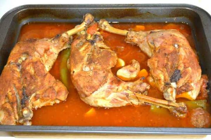 Oven slow roasted turkey legs with a deep golden crispy skin, served in a roasting tray with tender braised vegetables.