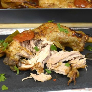 A serving of juicy, fall off the bone slow roasted turkey leg on the platter.