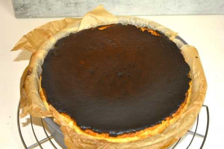 Freshly baked Basque burnt cheesecake with a puffed, dark caramelized top straight from the oven.