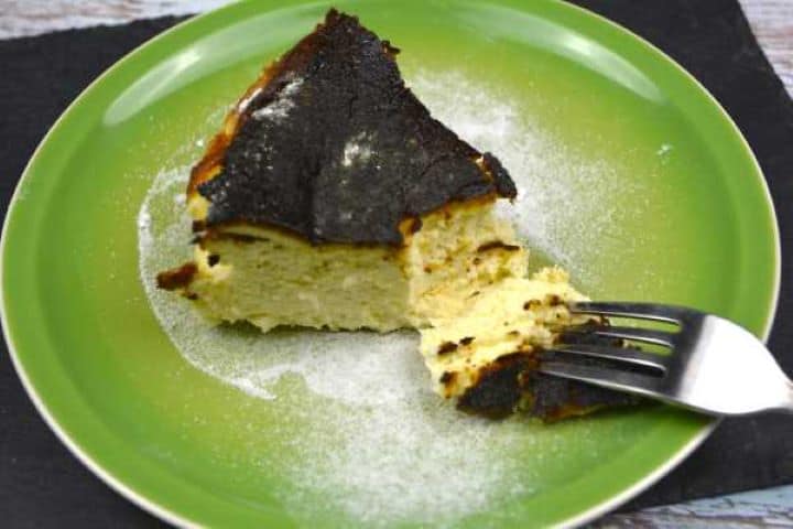 A slice of San Sebastián Basque cheesecake served on a dessert plate at room temperature.