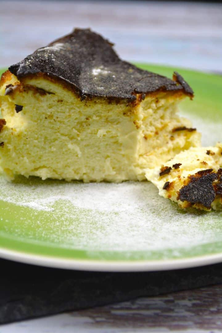 A slice of classic Basque burnt cheesecake showing the dark caramelized crust and ultra-creamy custard centre.