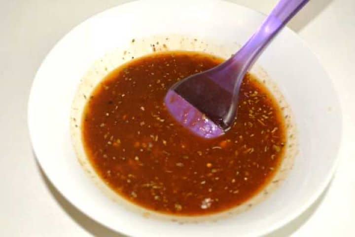 Whisking sunflower oil, soy sauce, garlic, honey, paprika, and herbs in a small bowl for the pork baste.