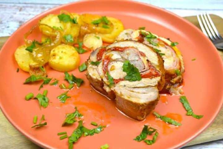 Ham and cheese stuffed pork loin slices served on the plate with fried potatoes.