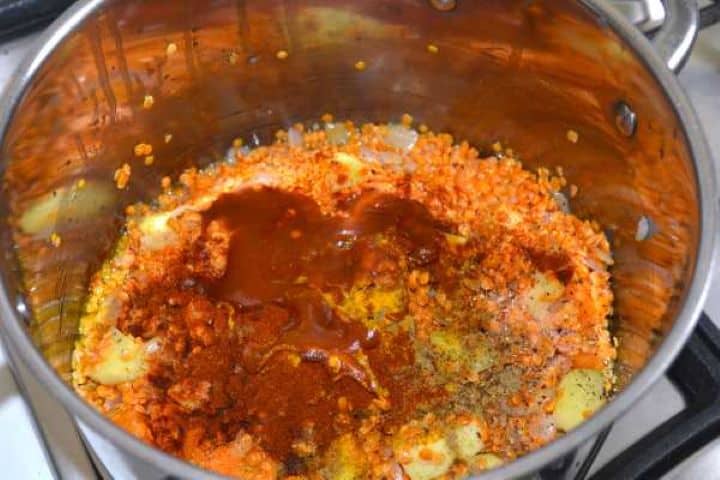 Rinsed red lentils, Hungarian paprika, turmeric, ground coriander, and tomato passata added to the vegetables in the pot.
