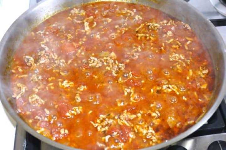 Simmering spiced lamb ragout with cinnamon and tomatoes for moussaka filling.