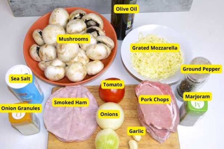 Ingredients for cheesy pork chops recipe including pork loin, portobello mushrooms, smoked ham, onion, tomato, and mozzarella.