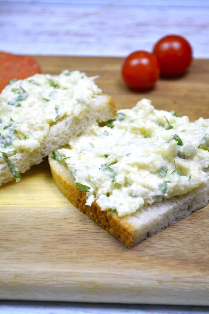 Creamy cauliflower spread served on rustic crusty bread with sliced salami and fresh cherry tomatoes.