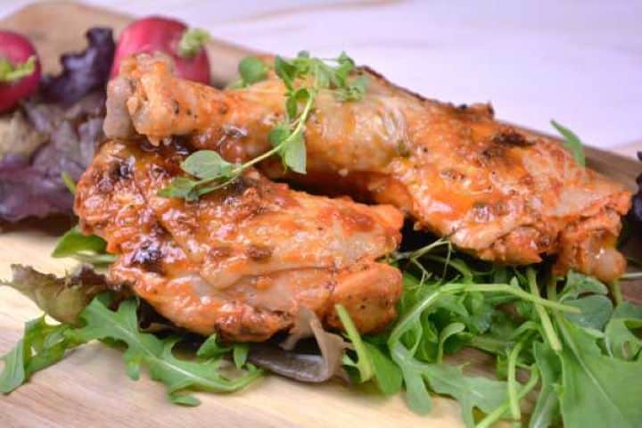 Served Roasted chicken legs in the oven served on the chopping board.