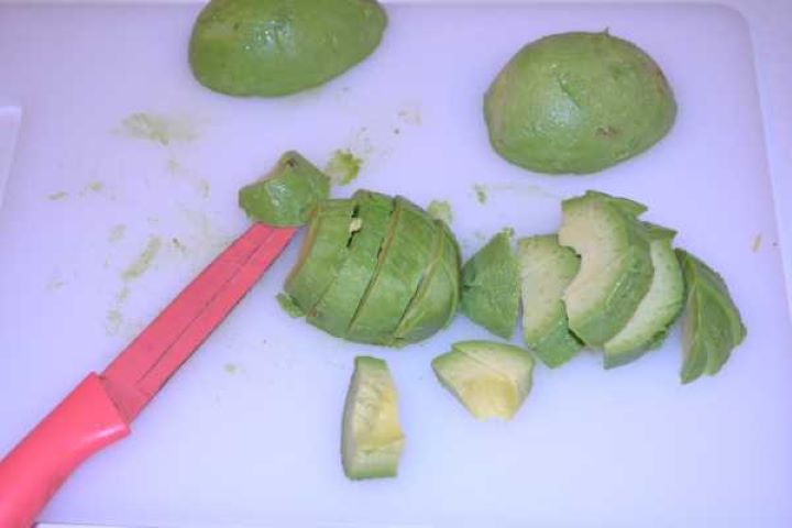 Cut Avocados Diced ripe avocado cubes on a white cutting board for fresh summer salad.