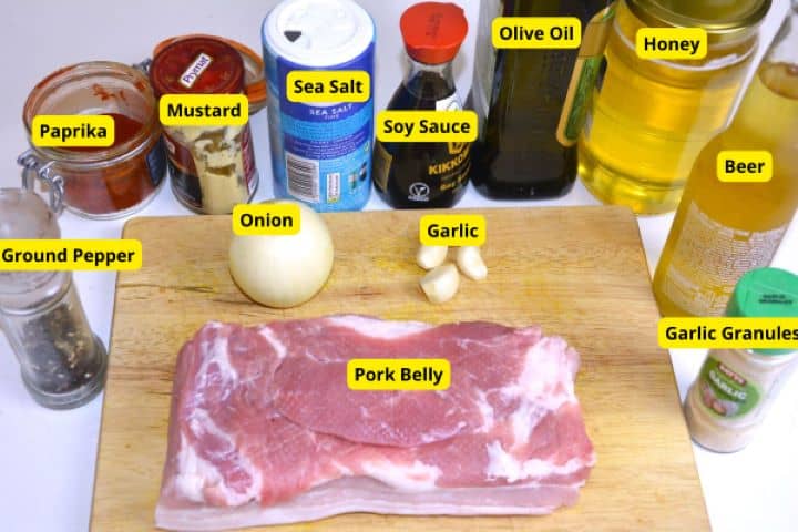 Raw pork belly slab, beer, onion, garlic, honey, soy sauce, and spices for honey glazed pork belly.