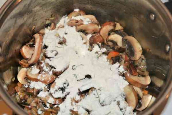 Best Mushroom Soup Recipe-Flour on the Frying Vegetables in the Pot Sprinkling wheat flour over sautéed mushrooms and vegetables to lightly thicken the broth.