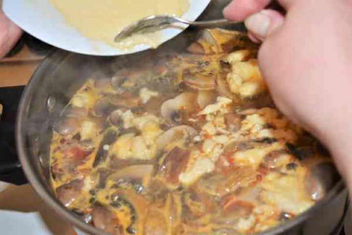 Best Mushroom Soup Recipe-Pouring Batter in the Soup Dropping small spoonfuls of nokedli dumpling batter directly into the simmering mushroom soup.