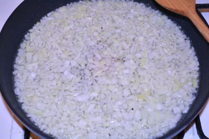 Layered Sauerkraut Casserole-Frying Chopped Onions in the Pan Sautéing finely chopped yellow onions with sea salt in a large frying pan.