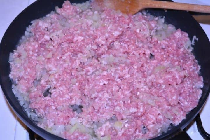 Layered Sauerkraut Casserole-Frying Pork Mince and Onions in the Pan Browning minced pork with diced onions in a frying pan until no longer pink.