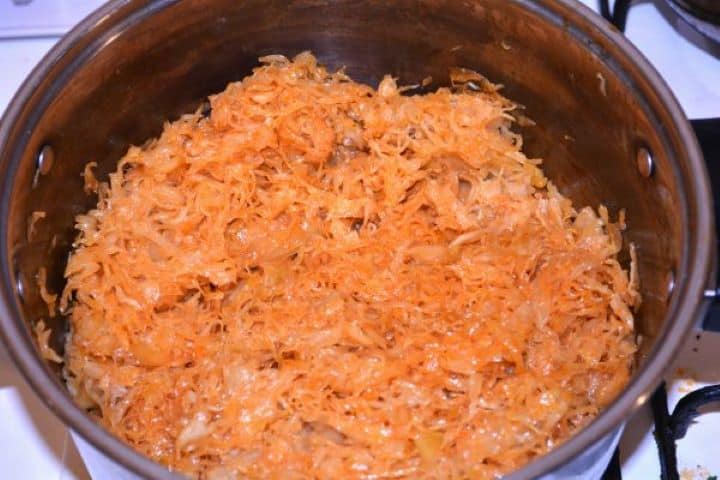 Layered Sauerkraut Casserole-Frying Sauerkraut in the Pot Tossing chopped sauerkraut with sautéed paprika onions in a soup pot.