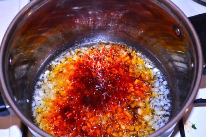 Layered Sauerkraut Casserole-Frying Seasoned Chopped Onions Sautéing diced onions with sweet Hungarian paprika in a soup pot for the sauerkraut.