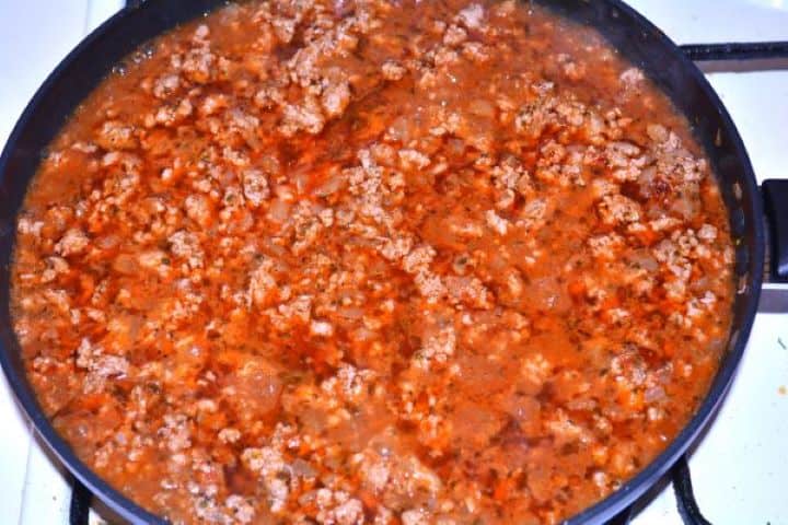 Layered Sauerkraut Casserole-Simmering Pork Mince in the Pan Simmering seasoned pork mince with water until thick, tender, and savory.