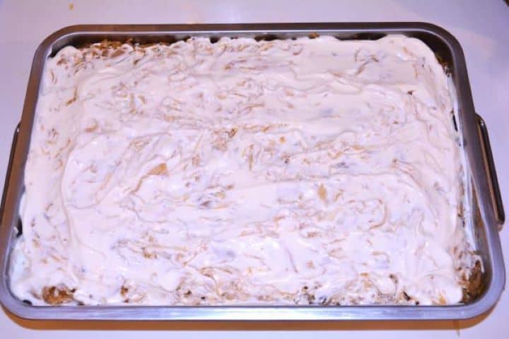 Layered Sauerkraut Casserole-Sour Cream on the Top of Cabbage Casserole Spreading a thick layer of sour cream evenly across the top layer of sauerkraut.